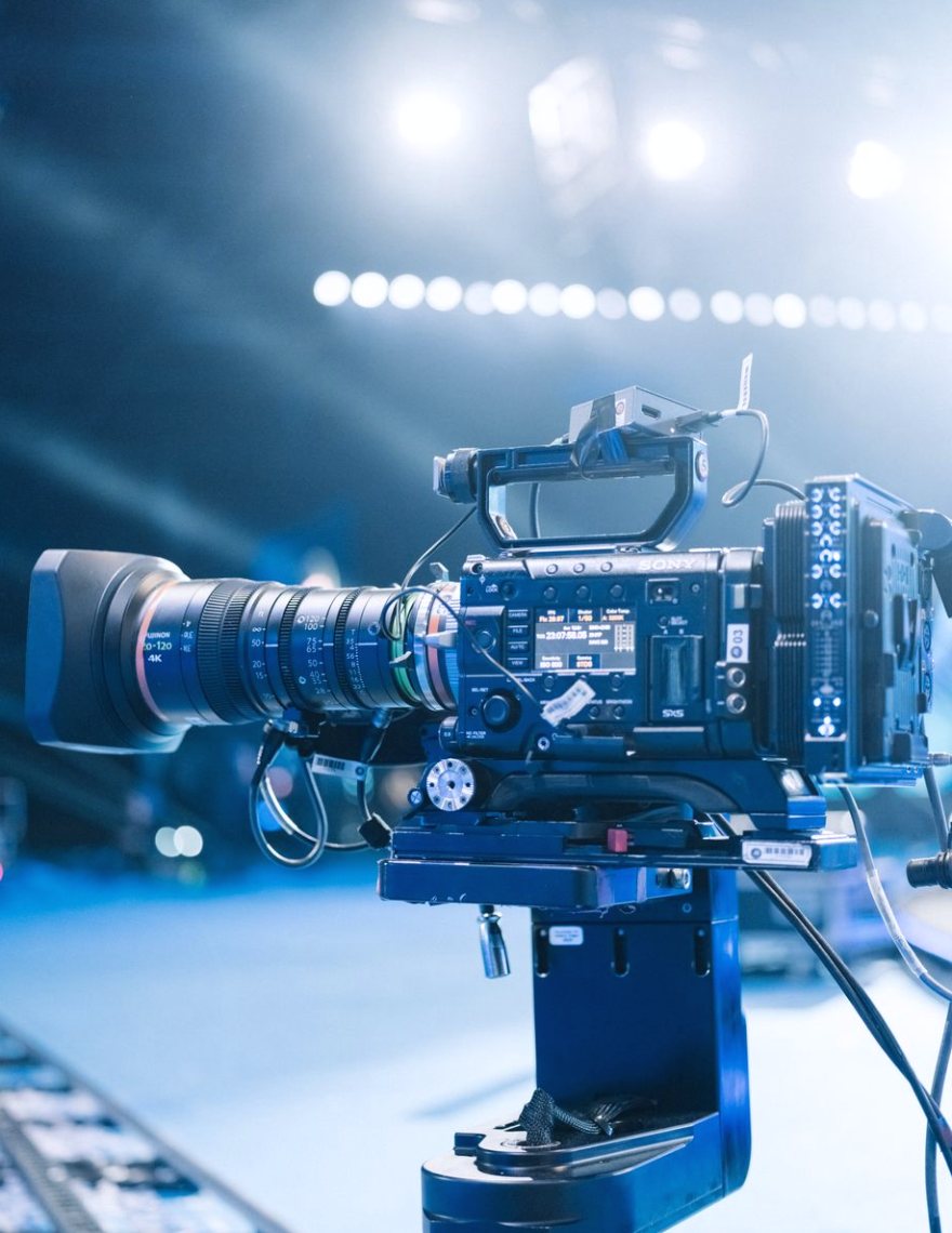 A studio crew checks camera positions and lighting on a news set before rehearsal.